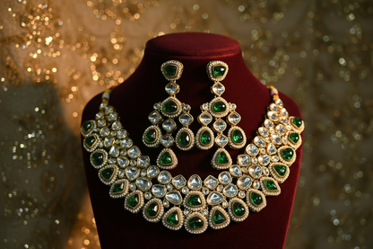 Green and gold jewelry set on a mannequin bust against a white background